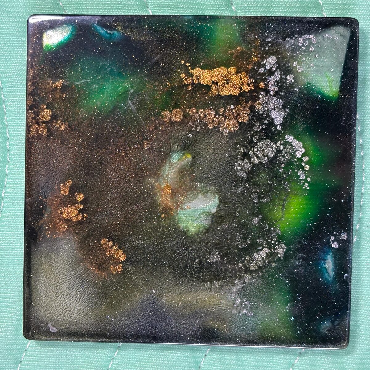 Dark square resin tray with green, silver, and gold galaxy-like shimmer