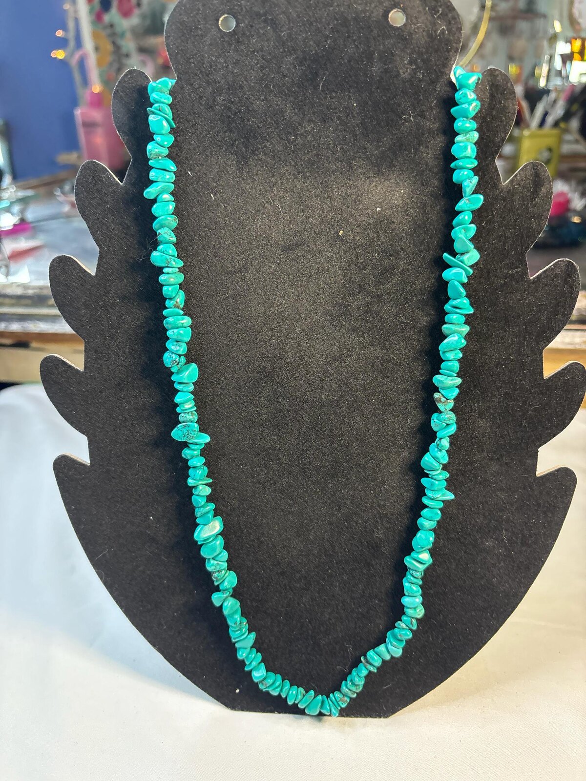 Turquoise chip 24 inch necklace on a black display bust